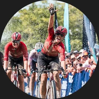 泥だらけのレースで勝利を喜ぶ女性サイクリスト