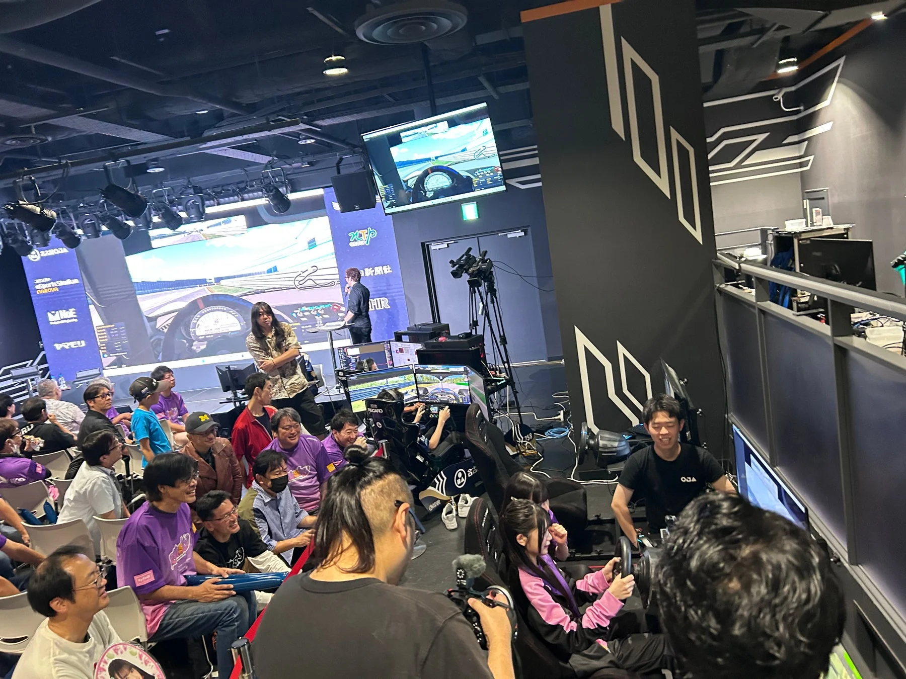 eスポーツイベントでレーシングシミュレーターを楽しむ観客