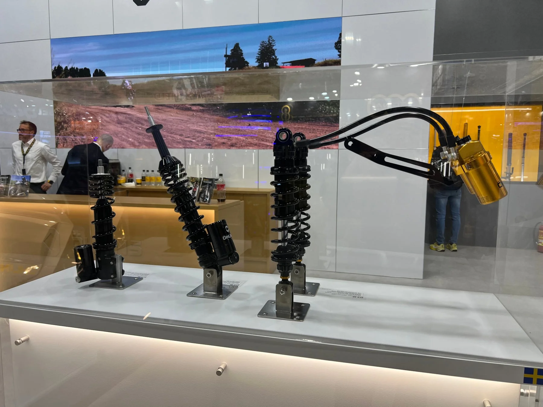 オートバイ用サスペンション部品が複数展示されているブース
