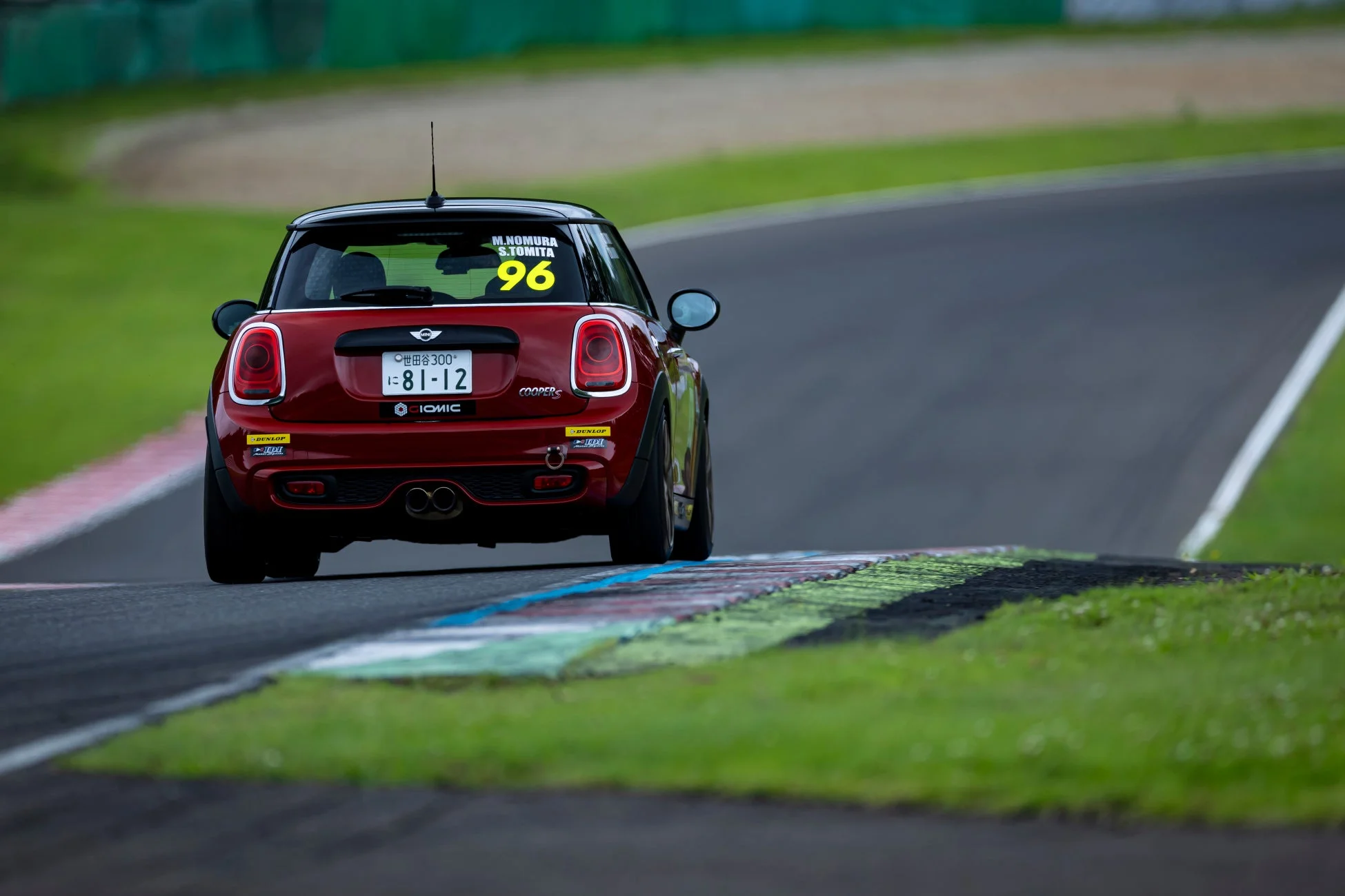 赤いミニクーパーSがサーキットを走行している後ろ姿