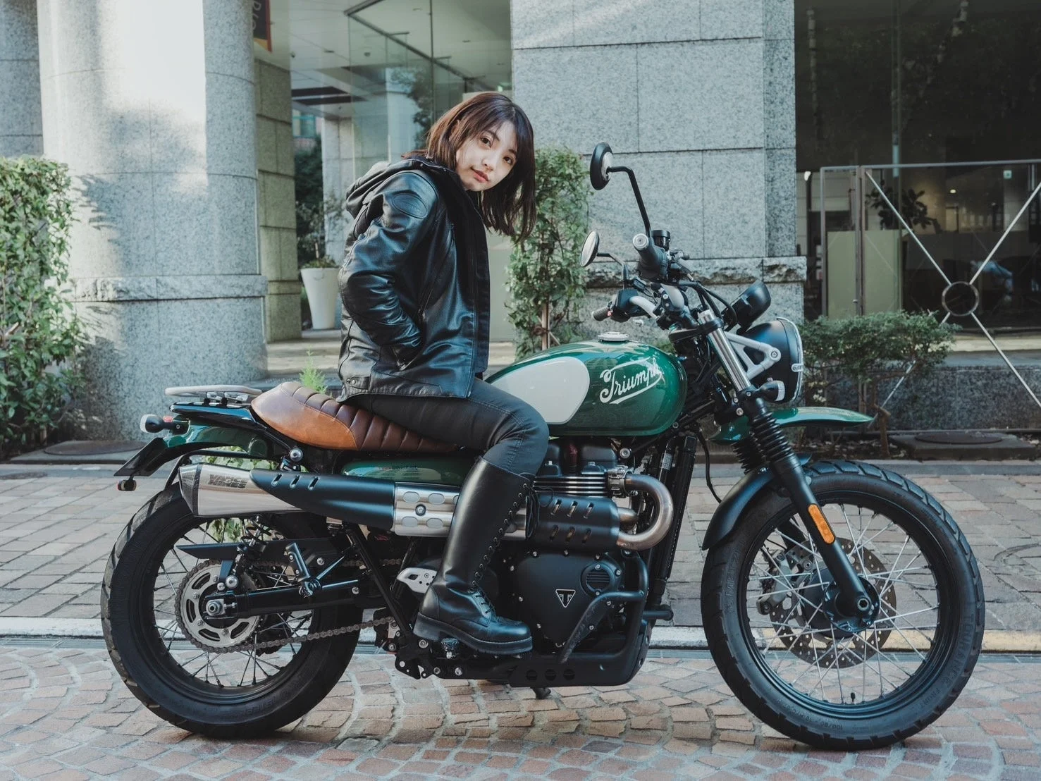 緑色のトライアンフバイクにまたがる女性